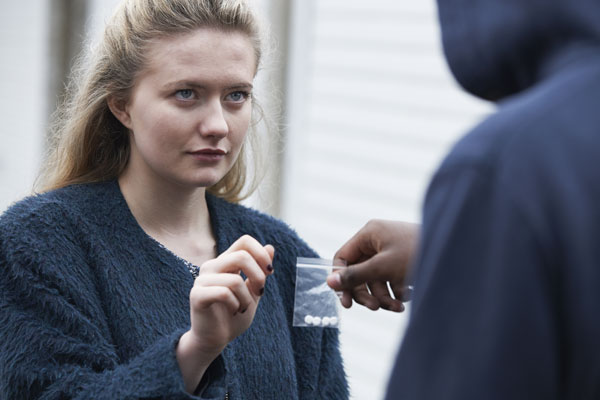 young woman buying pills from a drug dealer