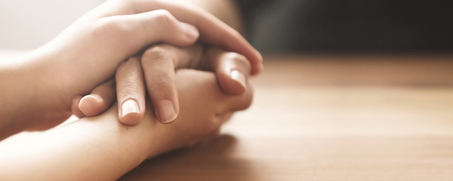 staff showing support by holding client's hand